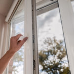 One sided open window. A hand opens a vinyl plastic window on a